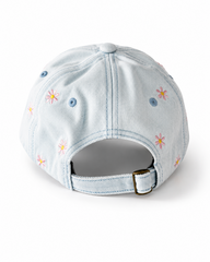 Back view of the light-wash flower-embroidered cap, showing the curved crown and the adjustable strap clipped into its brass buckle.