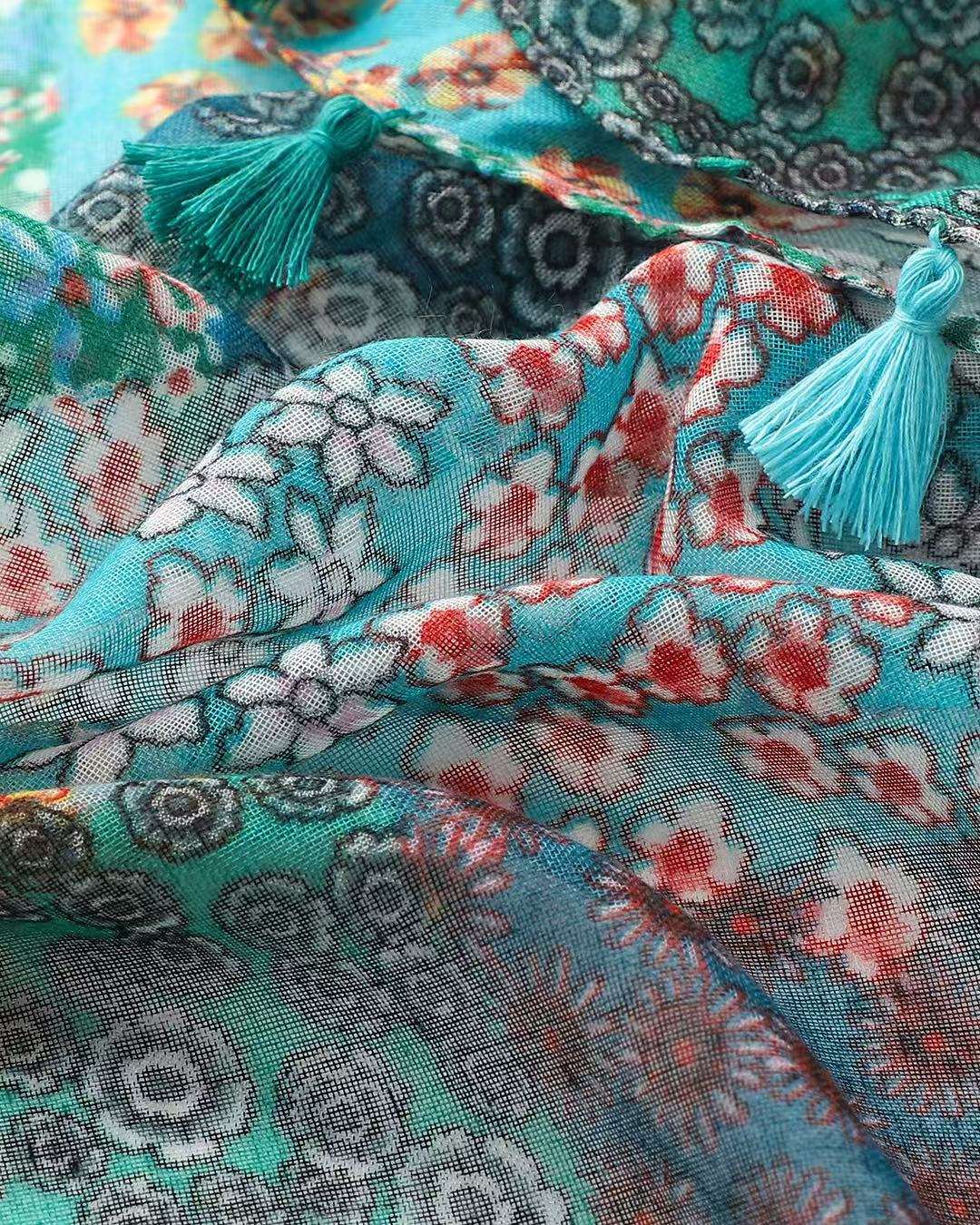 Close-up of turquoise and green bohemian patchwork print scarf with teal tassel