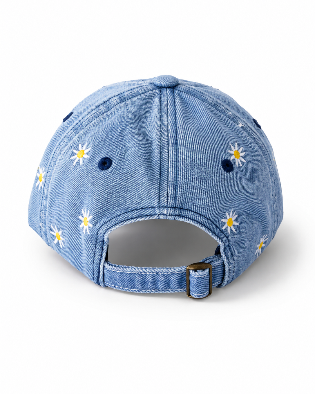 Back view of the mid-wash daisy-embroidered cap, showing the curved crown and the adjustable strap clipped into its brass buckle.