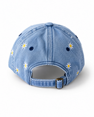 Back view of the mid-wash daisy-embroidered cap, showing the curved crown and the adjustable strap clipped into its brass buckle.