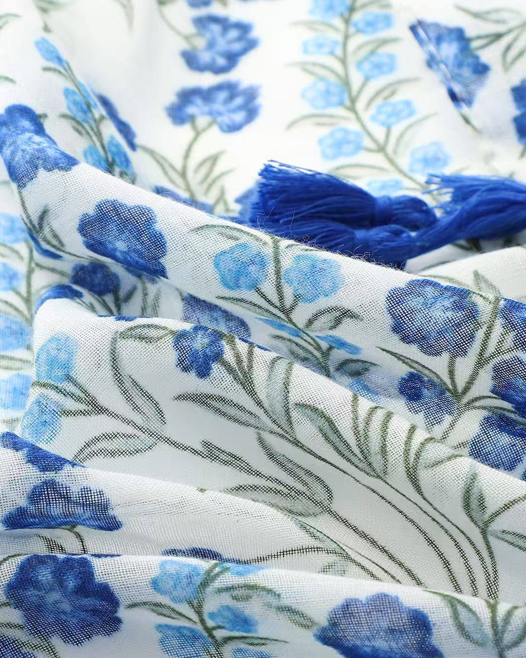 Close-up of blue floral field print scarf with sage green leaves