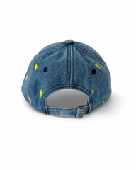 Back view of the mid-wash lemon-embroidered cap, showing the curved crown and the adjustable strap clipped into its brass buckle.
