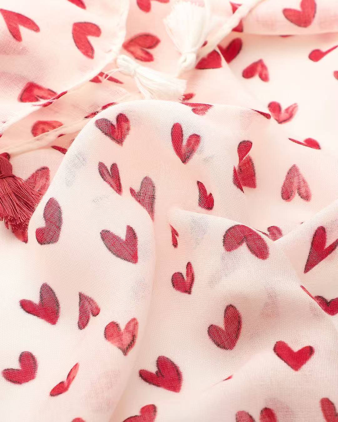 Close-up of red heart print on off-white lightweight scarf