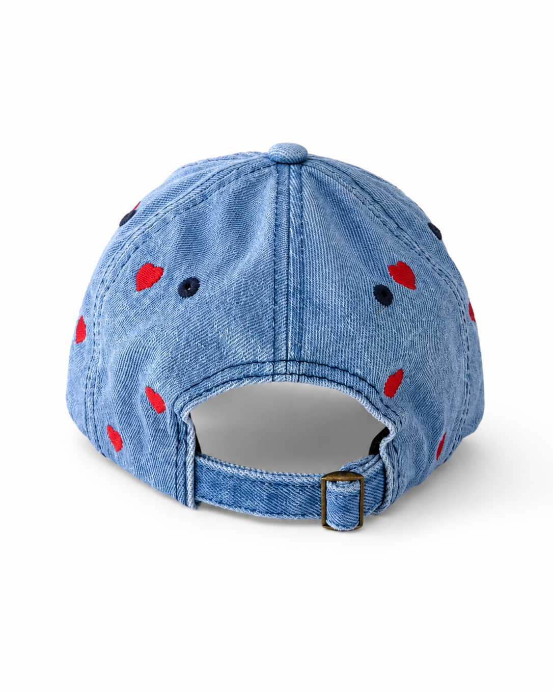 Back view of the mid-wash heart-embroidered cap, showing the curved crown and the adjustable strap clipped into its brass buckle.