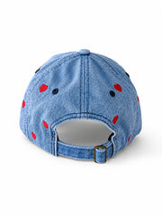 Mid-wash denim baseball cap embroidered with small red hearts, front view on a white background.