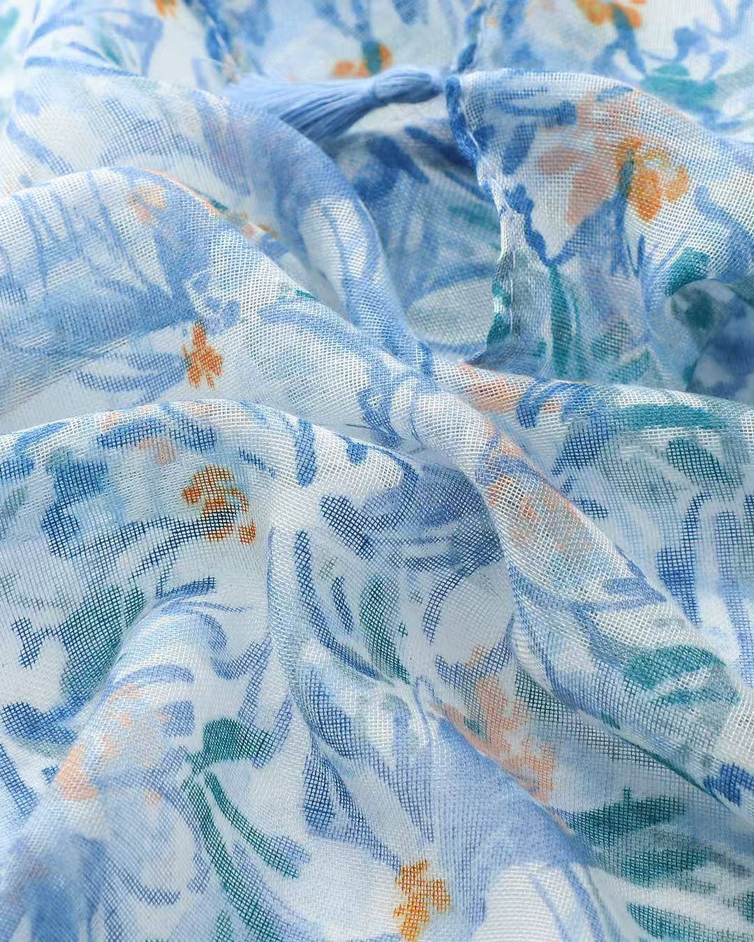 Close-up of blue and teal watercolour floral print scarf with peach accents
