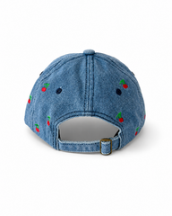 Back view of the mid-wash cherry-embroidered cap, showing the curved crown and the adjustable strap clipped into its brass buckle.