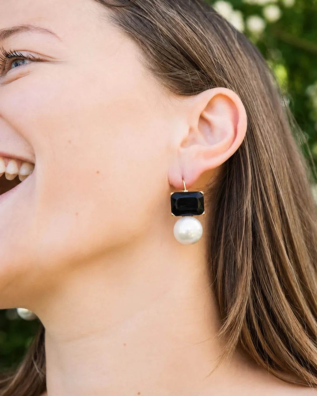 Woman wearing a black and pearl earring outdoors