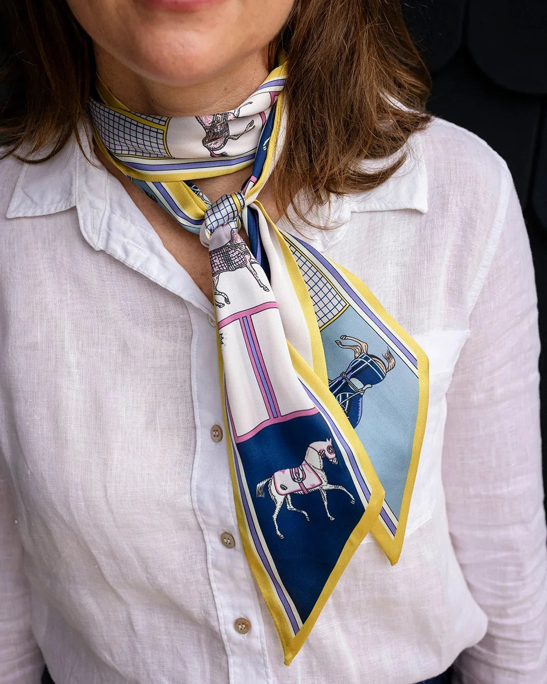 Satin neck scarf and bag tie in citrine yellow horse print styled around the neck