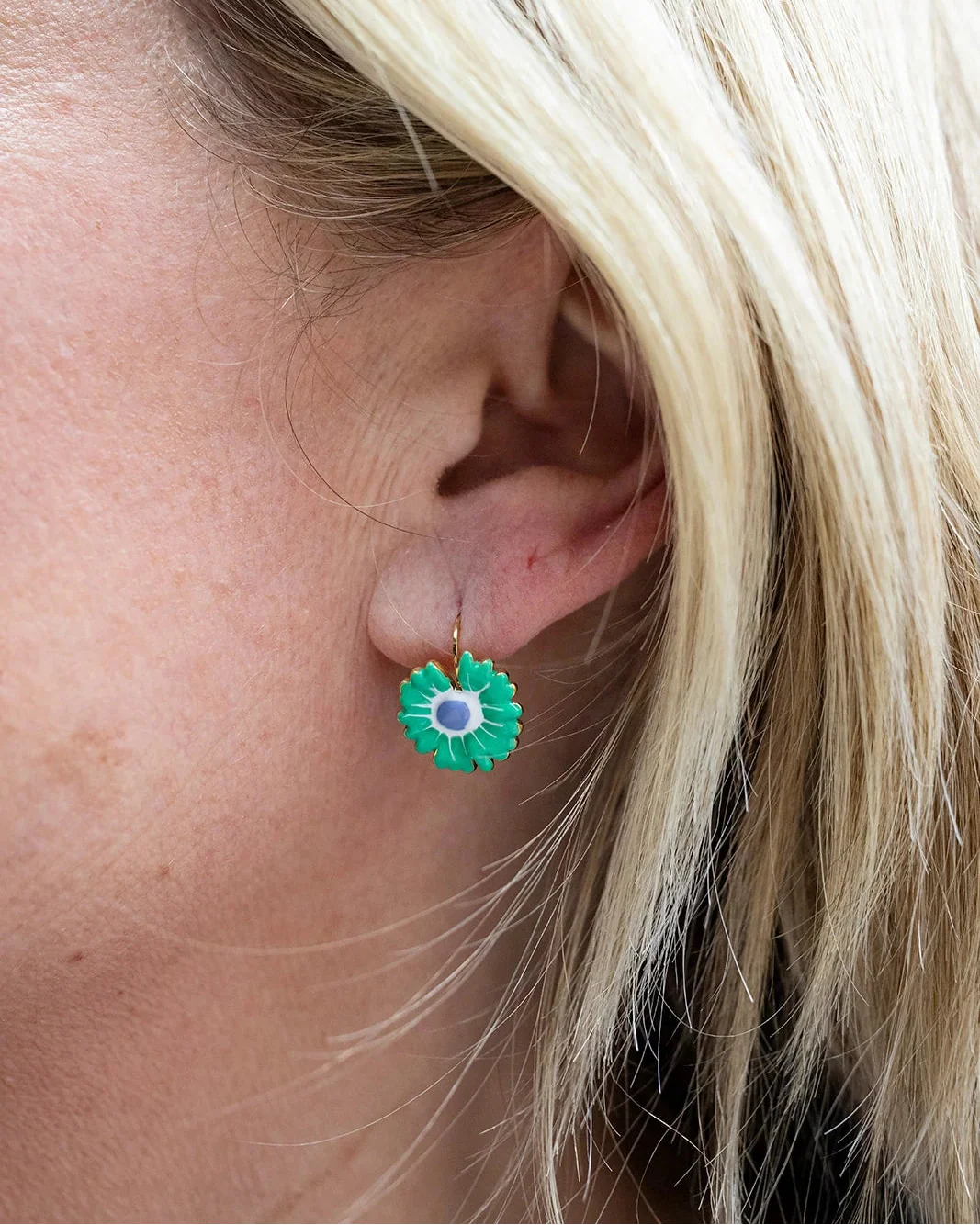 Gold hoop earrings with a green enamel zinnia flower charm and purple centre