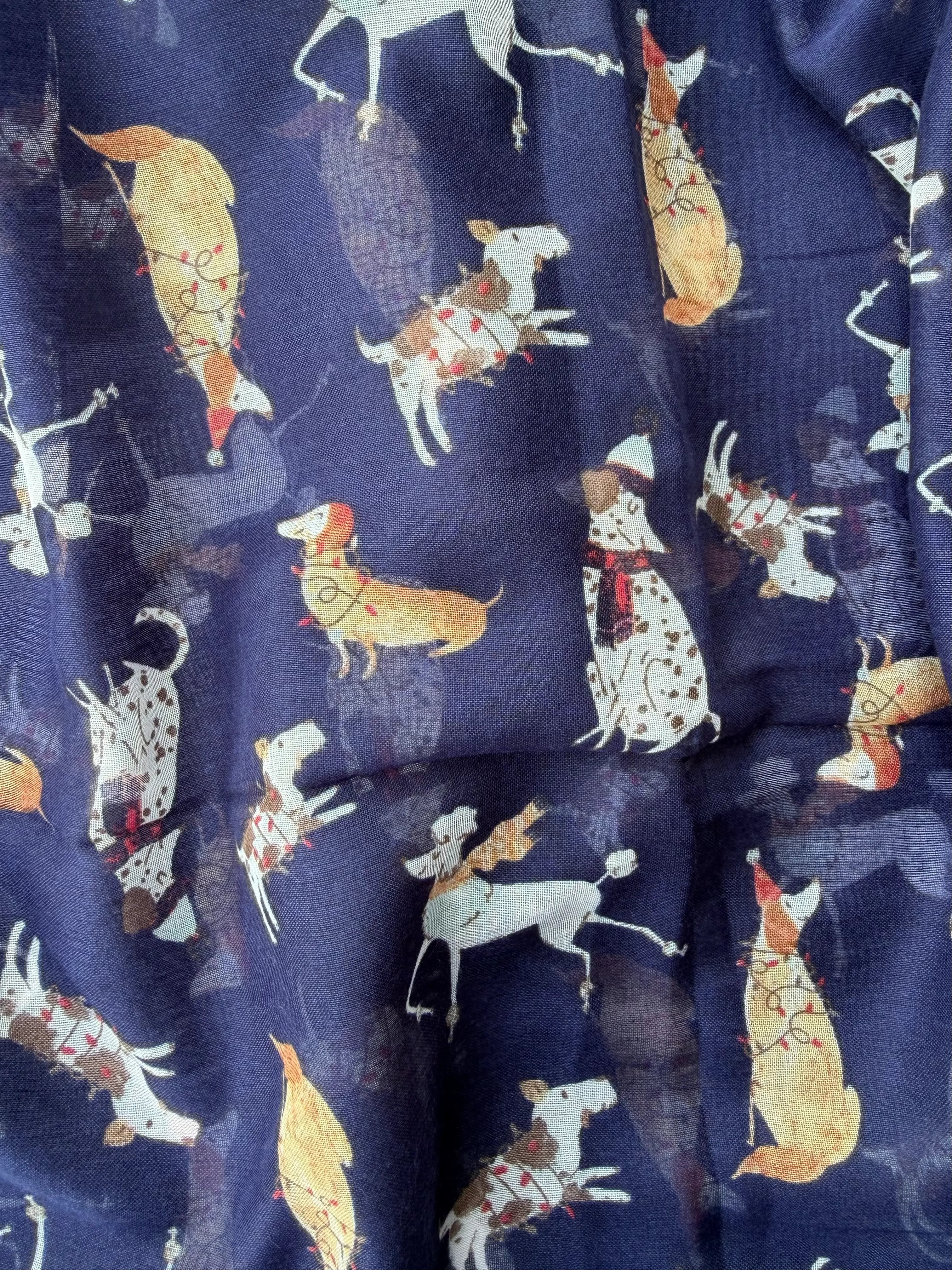 Lightweight navy scarf printed with small white, brown and tan dogs, finished with navy and tan tassels