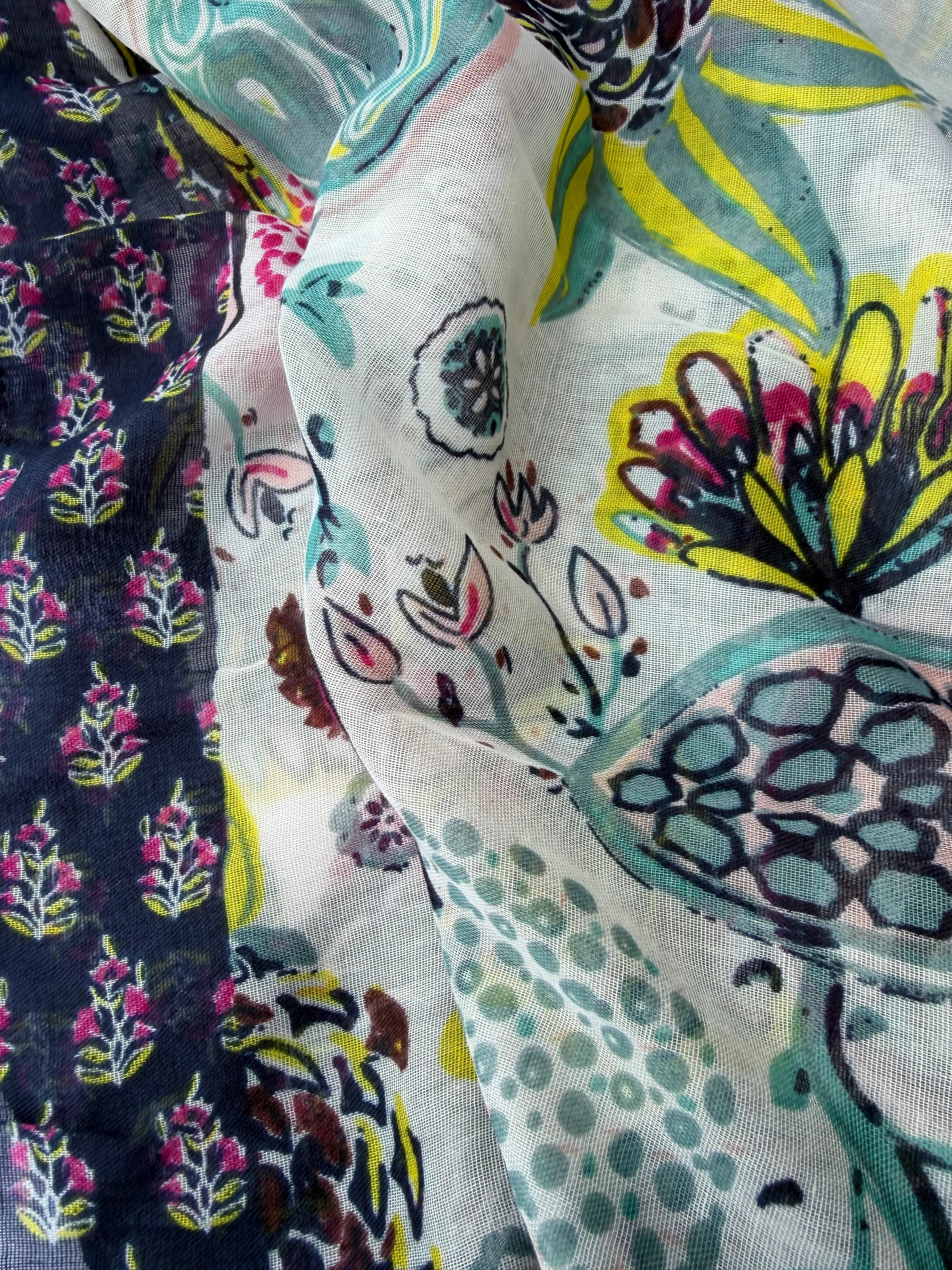Lightweight scarf with an abstract floral print in bright pink, aqua, brown and yellow on white, framed by a navy floral border, with pink and navy tassels