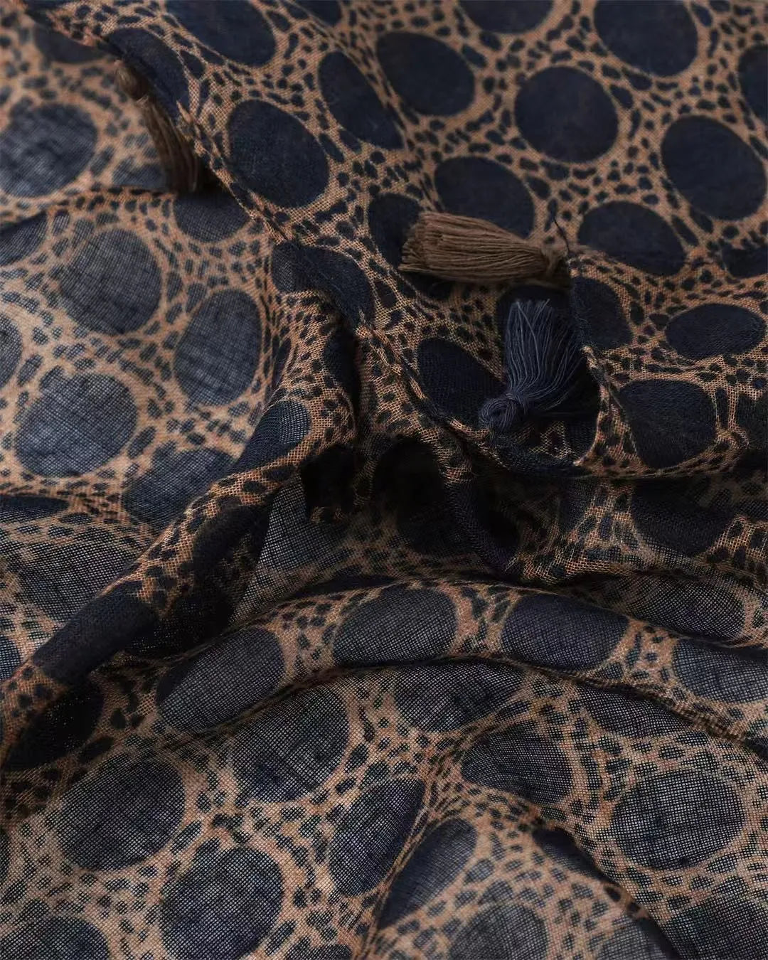 Tan animal print lightweight scarf with navy spots and tassels