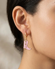 Woman wearing pink enamel cowboy boot dangle earrings with gold hoop