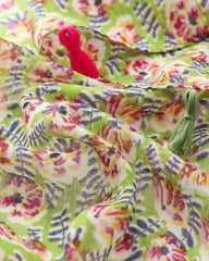 Close-up of green and pink floral print on lightweight scarf fabric with tassel