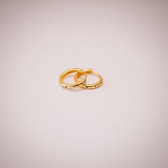 Gold hoop earrings with multi coloured crystals on white background