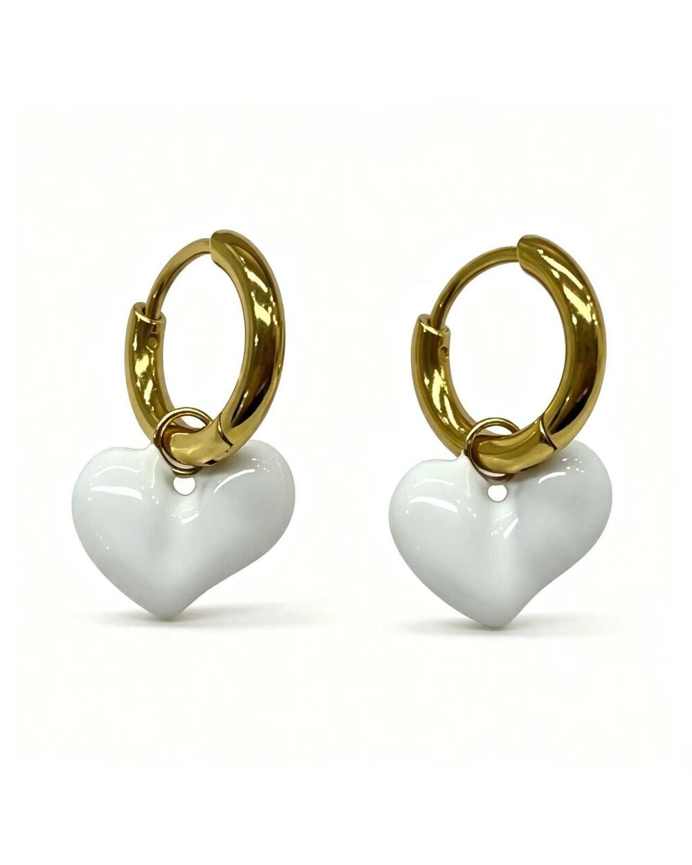 Gold hoop earrings with a white enamel heart charm dangle