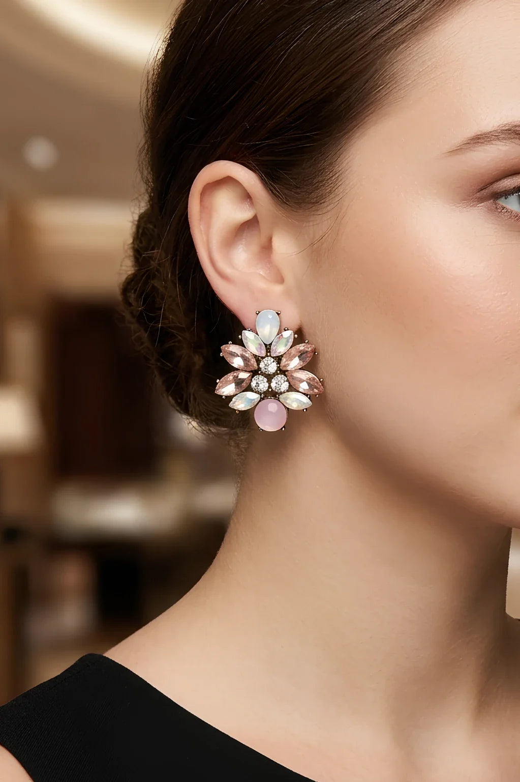 Woman wearing Peta soft pink crystal cluster stud earrings by Greenwood Designs, styled with a black top in an elegant indoor setting