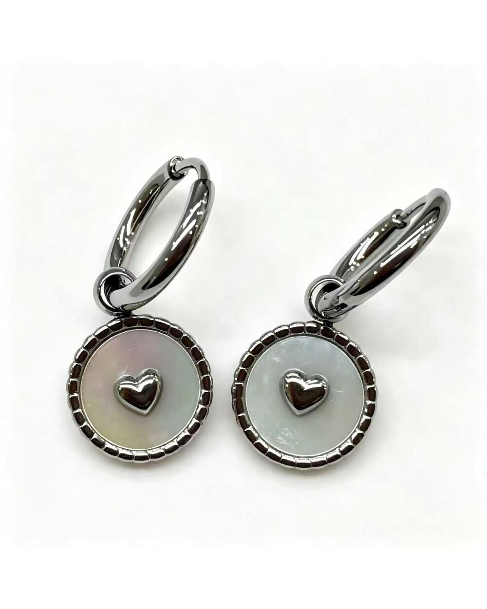 Silver hoop earrings with a white enamel heart charm medallion dangle