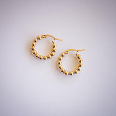 Gold ball hoop earrings on white background